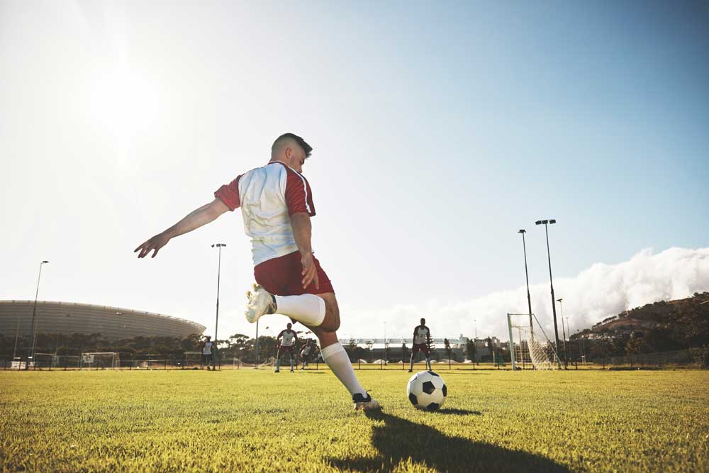 Soccer player kicking a soccer ball on the field