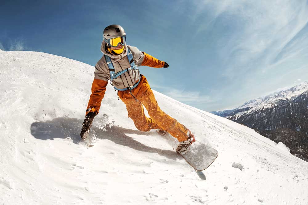 Snowboarder riding through fresh powder snow