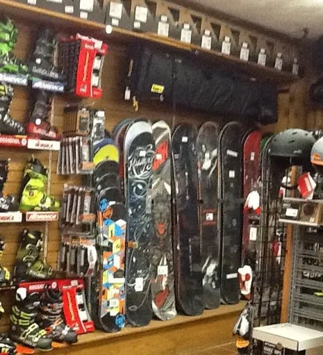 Rack of seasonal ski and snowboard rental equipment for adults and kids